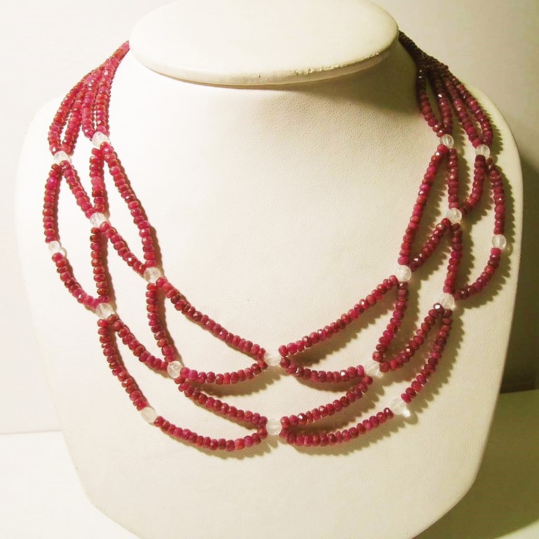 Collana tessuta, in rubini a rondella sfaccettati, e chiari di luna taglio rosetta, chiusura a bacchetta in oro bianco 750/000.