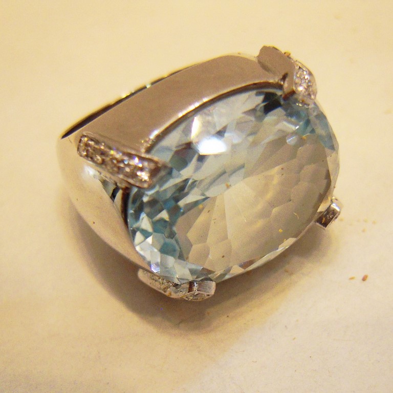 Anello in oro bianco 750/000 con grande aquamarina ovale, e brillantini incasonati sulle griffe.