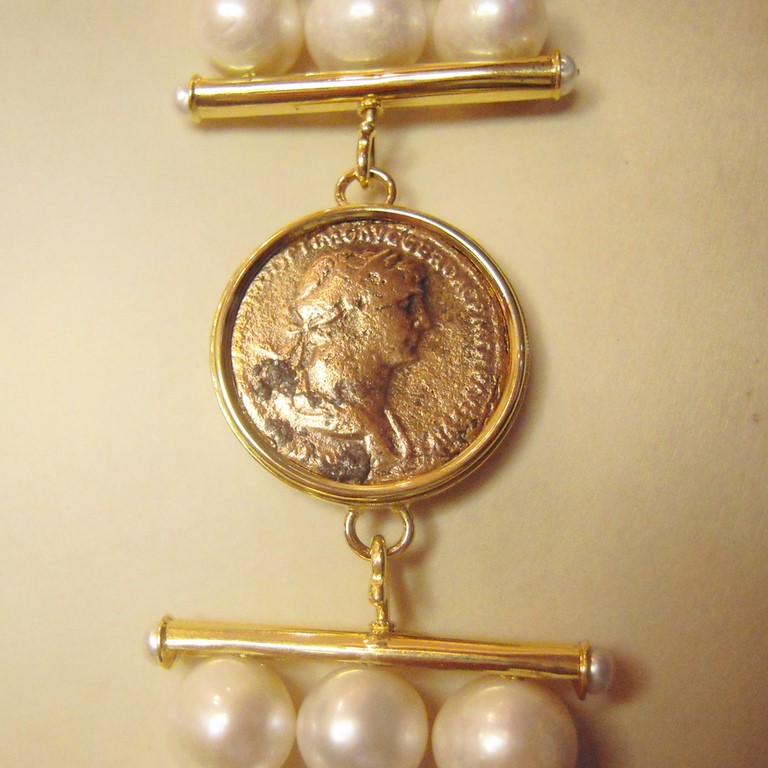 Chiusura in oro giallo 750/000 con moneta di bronzo, per tre fili di perle in gradazione.