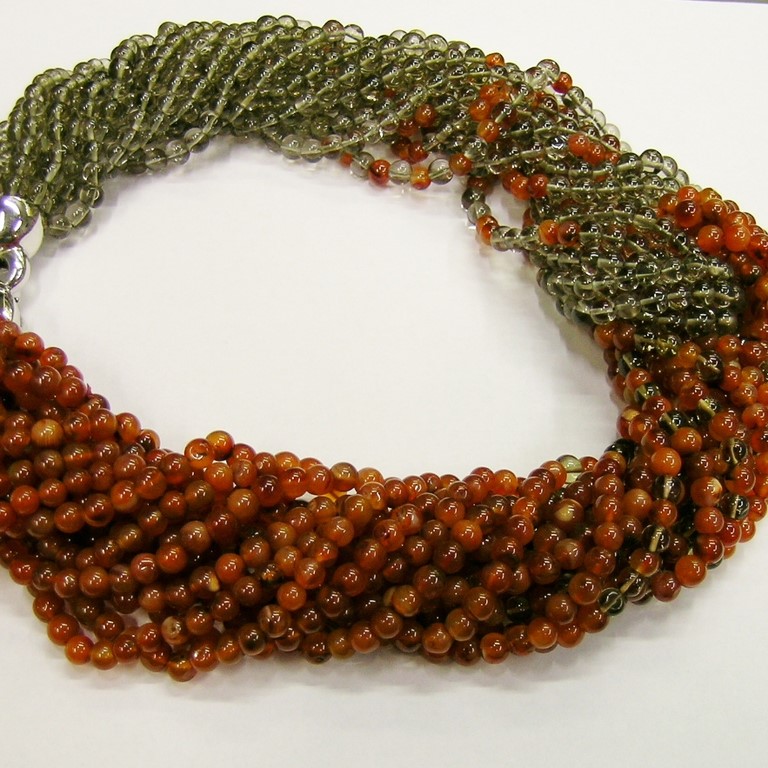 Collana multi fili in cristallo fumè, e corniola naturale montata sfumando i colori, con un'infilatura torsadè. Chiusura in argento 925/000.